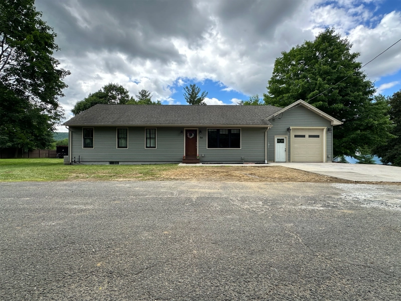 Before editing exterior photo of single-story American house with worn driveway, limited lawn coverage, dull sky, and visible street distractions.jpg Before editing exterior photo of single-story American house with worn driveway, limited lawn coverage, dull sky, and visible street distractions.jpg