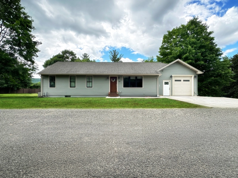 Single-story American home exterior after real estate photo editing with enhanced green lawn, clean driveway, restored road surface, bright blue sky, and polished curb appeal.jpg Single-story American home exterior after real estate photo editing with enhanced green lawn, clean driveway, restored road surface, bright blue sky, and polished curb appeal.jpg